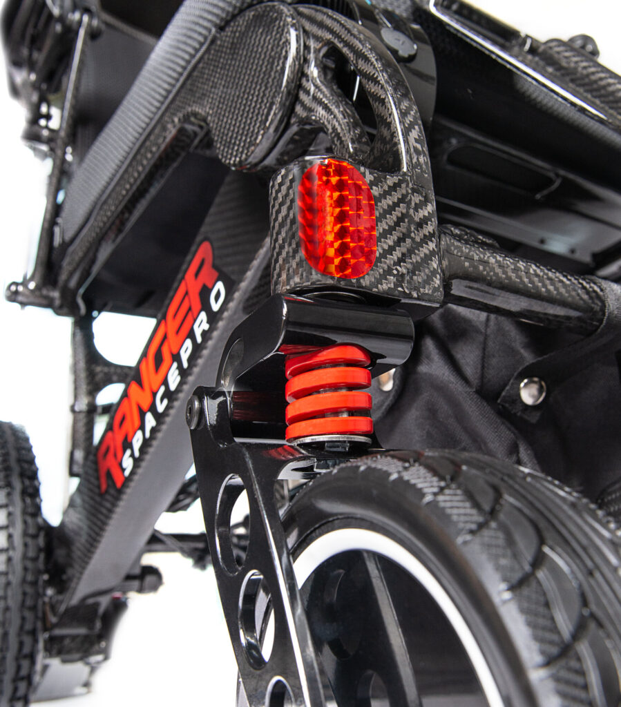 Porto Mobility Ranger SpacePro folding power wheelchair, front caster spring and reflector close up